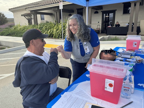 Volunteer fist bumps patient at event